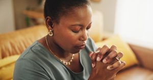Praying, praise and black woman in home for worship, faith and hope for spirituality. Belief, relig