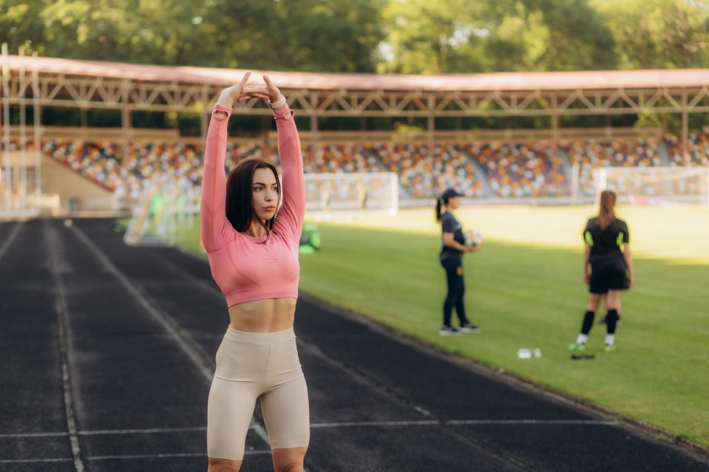 Training on the street, a young female athlete makes a workout on the street platform. Female athlet