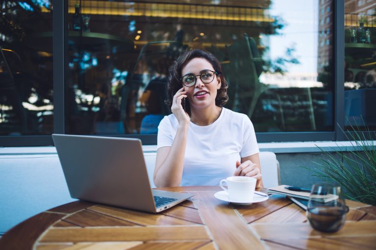 Busy freelancer talking on smartphone on terrace