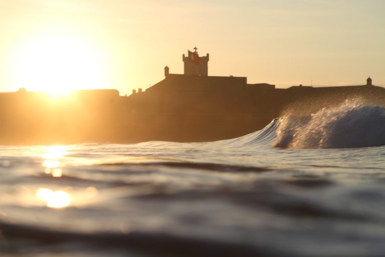 sun rise at Carcavelos beach with Sao Juliao forte as background,Portu
